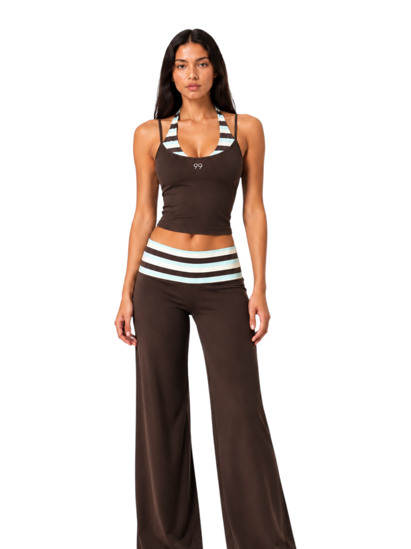 Model wearing Ninety Nine brown activewear set with halter top and wide-leg pants featuring retro stripe trim