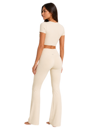 Model wearing Ninety Nine vanilla beige crop top and high-waisted V-cut flare leggings from behind