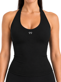 Ninety Nine black halter top with a deep scoop neckline and fitted silhouette worn by a model
