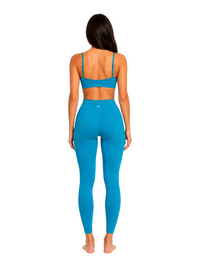 Back view of a woman wearing a Ninety Nine Aqua Muse set featuring a bright aqua blue crop top and high-waisted leggings.