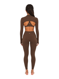 Model wearing Ninety Nine cocoa brown cutout long sleeve top and high waisted leggings set from the back view