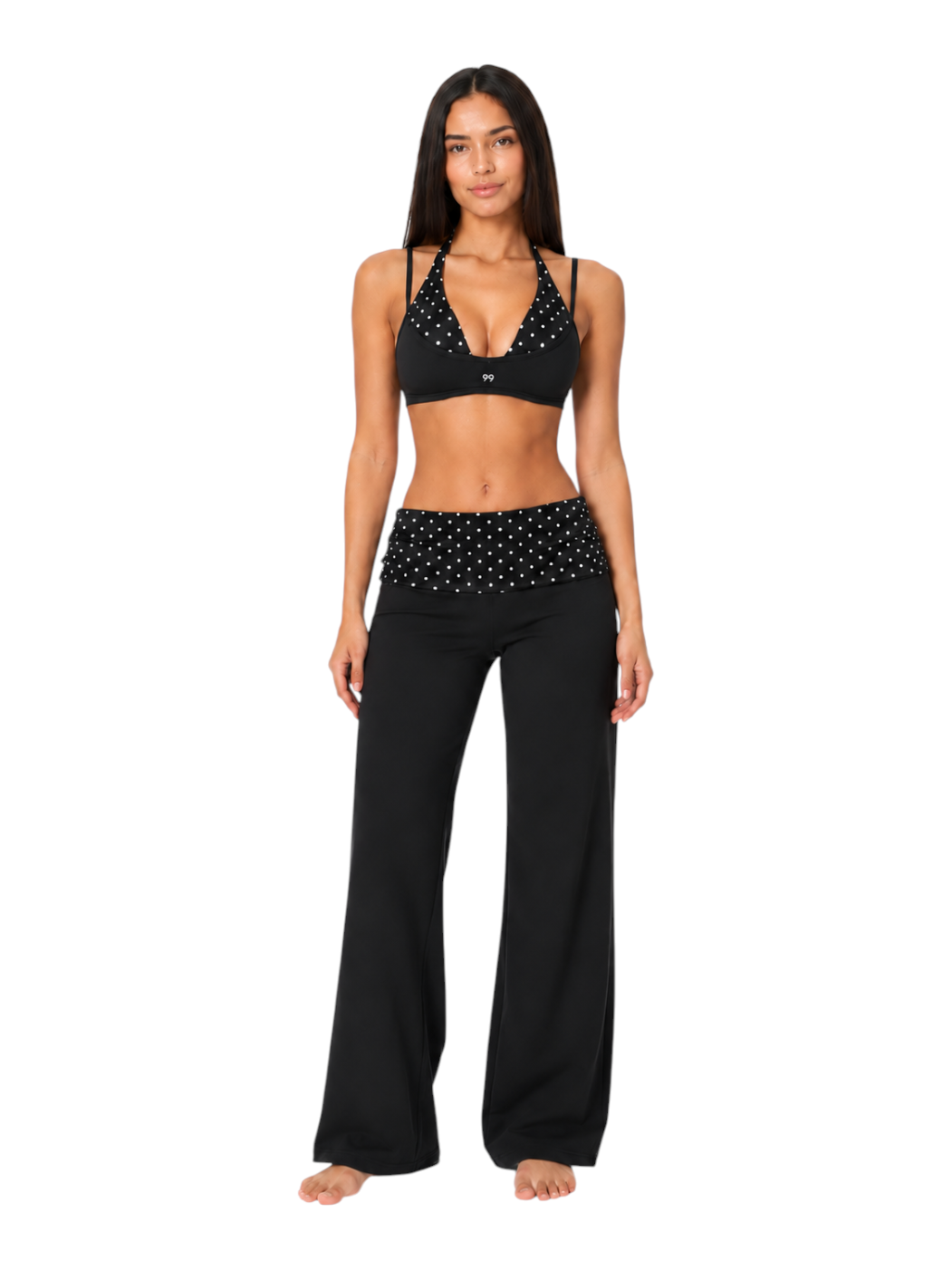 Ninety Nine Polka Noir set featuring a black polka dot halter sports bra and matching high-waist flared yoga pants.