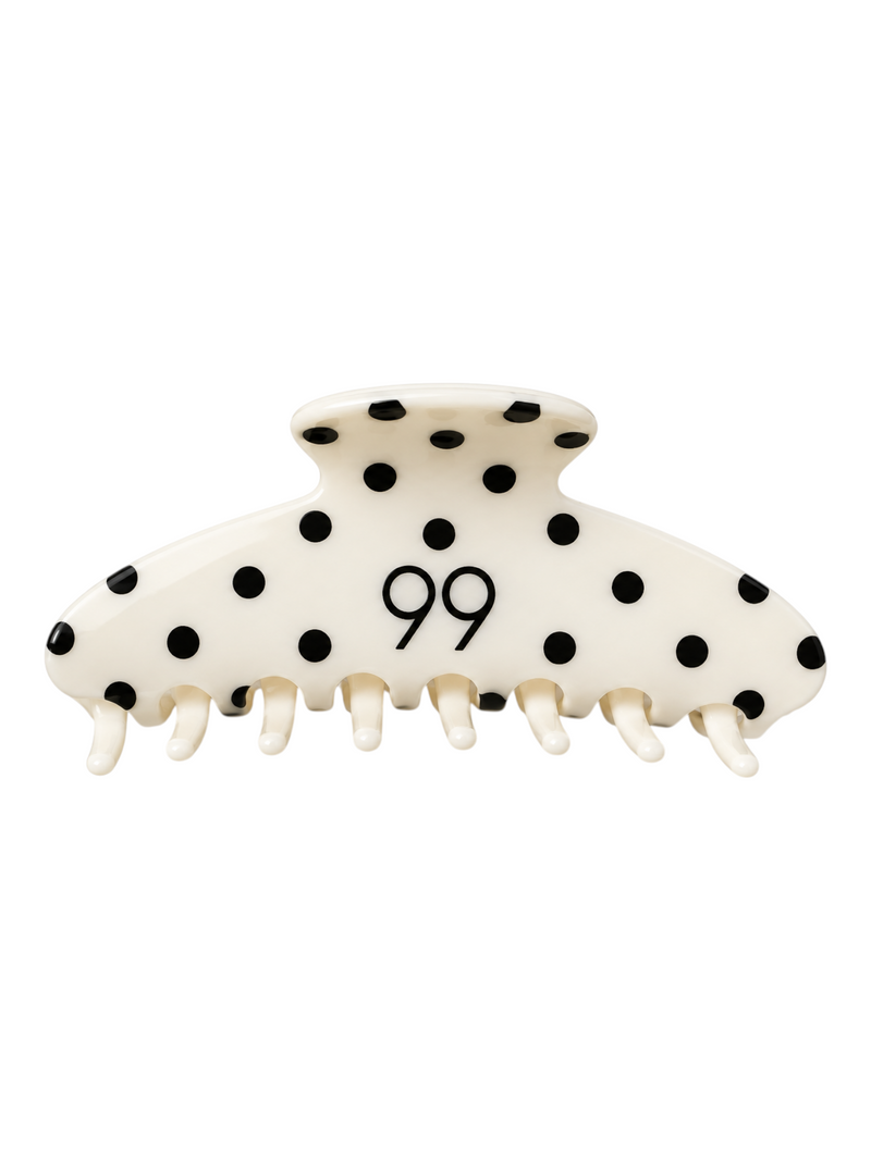 Ninety Nine hair claw clip in cream with black polka dots and a central 99 logo, featuring a strong grip design.