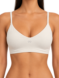 Ninety Nine off-white crop top with V-neckline and adjustable straps in breathable stretch nylon spandex fabric